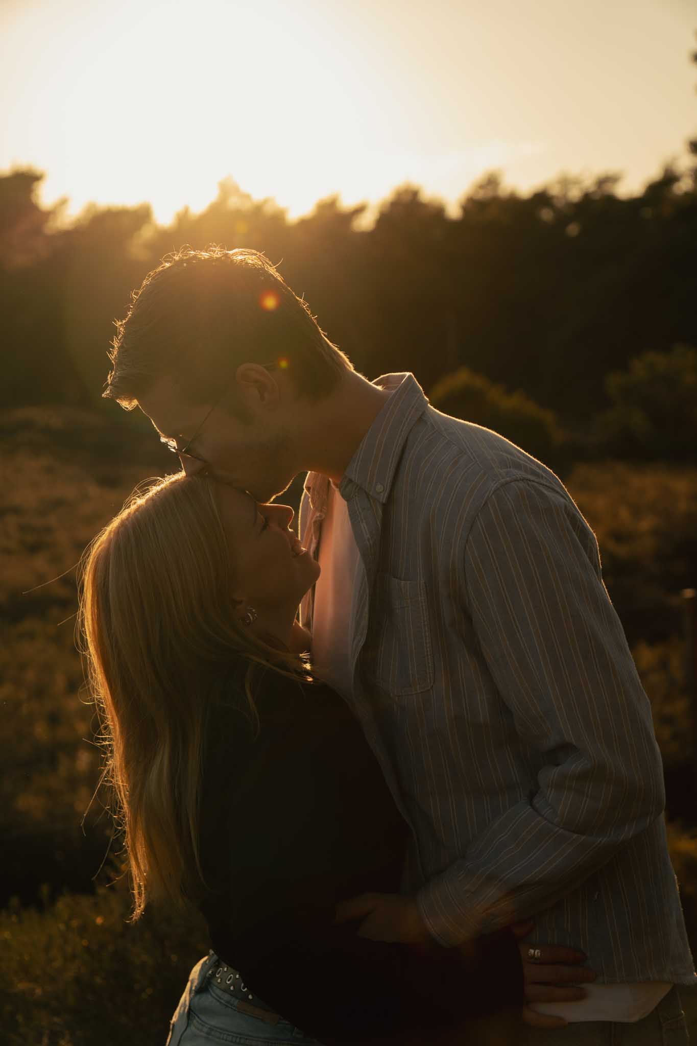 Een koppel hand in hand waarbij de vrouw een pirouette maakt, staand in de heide