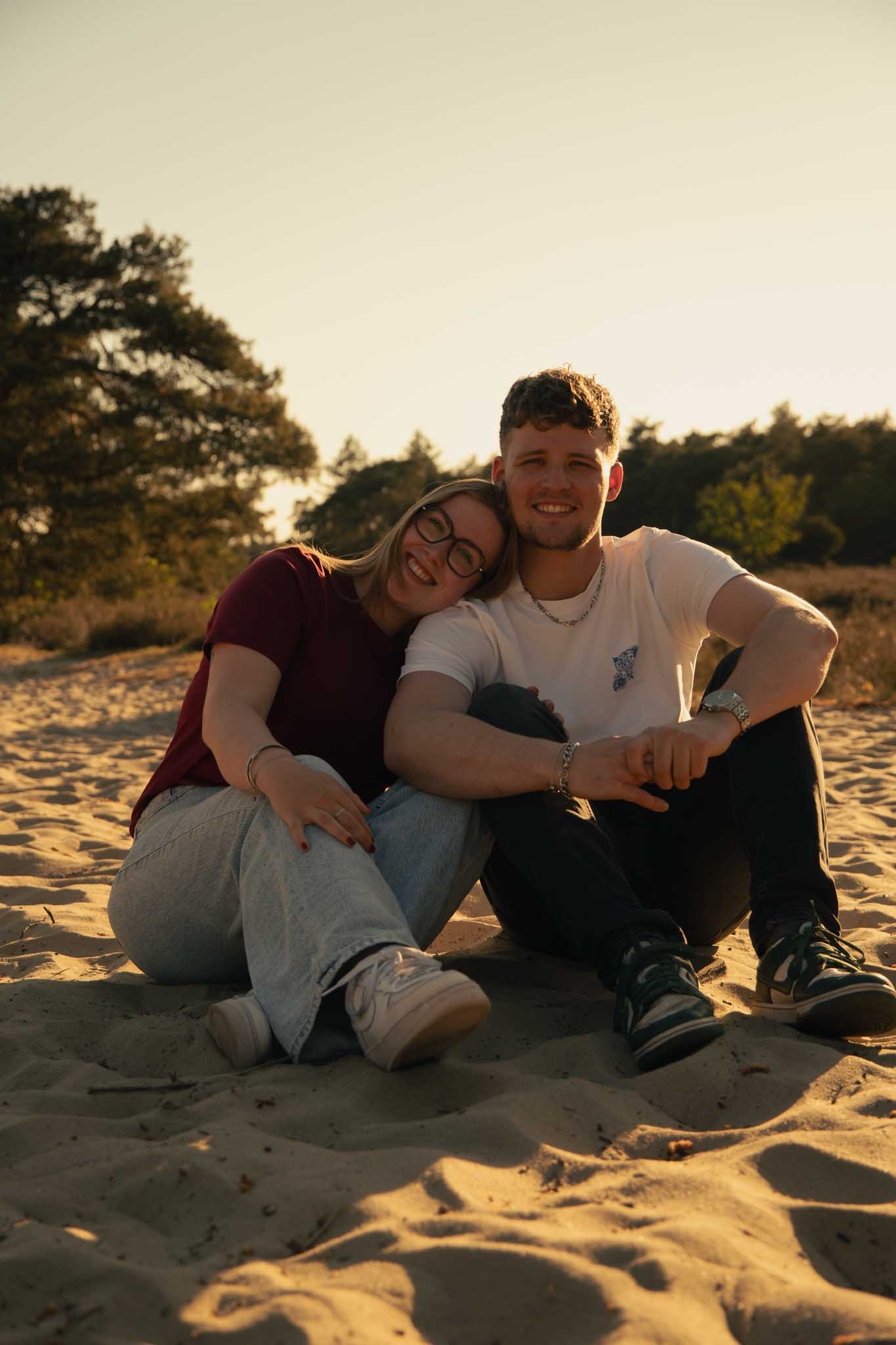 Een koppel hand in hand waarbij de vrouw een pirouette maakt, staand in de heide